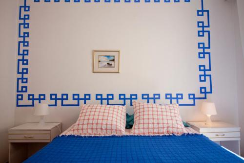 a bedroom with a blue and white headboard and a bed at Hostel Seixe in Odeceixe