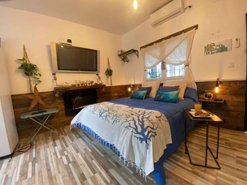 a bedroom with a bed and a tv on the wall at Beach house MAREA CORAL in Melilla