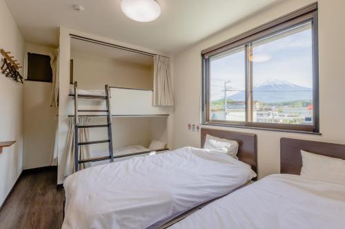 a bedroom with two beds and a window at Holiday home Furinkazan 風林火山 in Fujikawaguchiko
