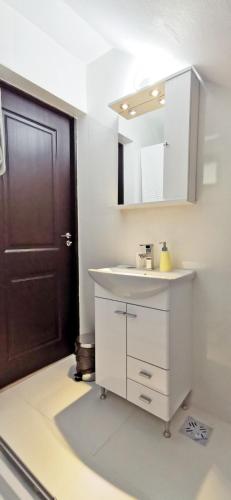 a bathroom with a white sink and a black door at Complex Parc Pini Moinesti in Moineşti