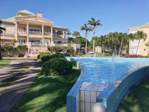 uma piscina com uma fonte em frente a um edifício em Studio CocoCaraïbes Anse des Rochers vue mer - piscine em Belle-Allée