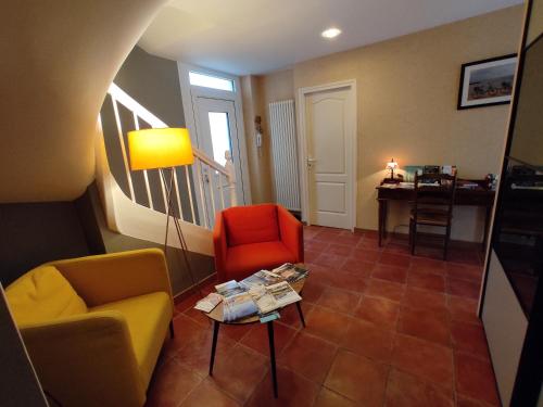 a living room with two chairs and a table at Aux Trois Palmiers in Saint-Brieuc