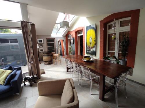 a living room with a wooden table and chairs at Aux Trois Palmiers in Saint-Brieuc