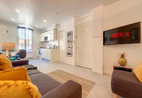 un salon avec un canapé et une télévision sur un mur dans l'établissement Nestor&Jeeves - L'ANCRE - Port district - Close Old Town, à Nice