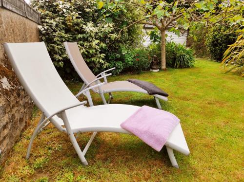 two chairs sitting on the grass in a yard at Aux Trois Palmiers in Saint-Brieuc