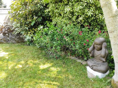 a statue of a little girl sitting in the grass at Aux Trois Palmiers in Saint-Brieuc