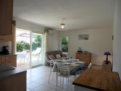 une cuisine et une salle à manger avec une table et des chaises dans l'établissement Appartement cosy à Capbreton: Jardin, Terrasse, Parking, Wi-Fi, à 300m de la Plage - FR-1-413-133, à Capbreton