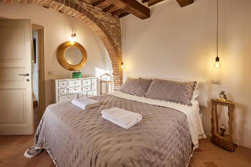 a bedroom with a bed with two towels on it at La finestra - centro storico Montepulciano, casa panoramica. in Montepulciano