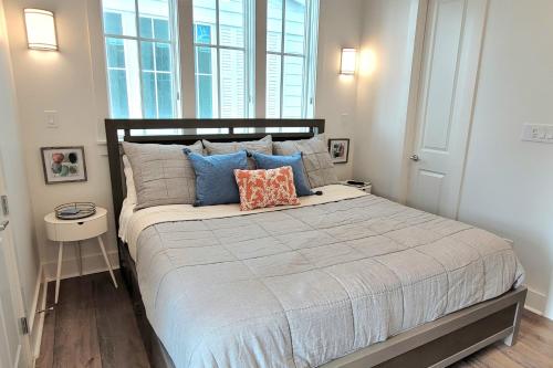 1 dormitorio con 1 cama grande con almohadas azules en Sunset Townhomes II, en Port Aransas