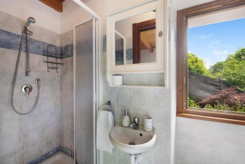 Dosso del LiroにあるLa Fonte di Mariella Monolocale 2のバスルーム(シンク、シャワー付)、窓が備わります。