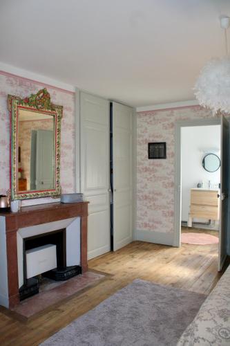 a living room with a fireplace and a mirror at Clos Ceres in Viré