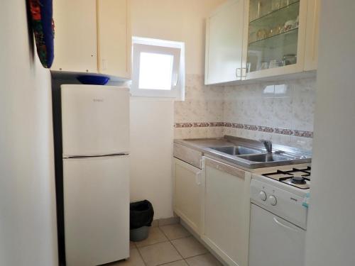 スタリグラードにあるApartments Darijaの白い冷蔵庫とシンクのあるキッチン