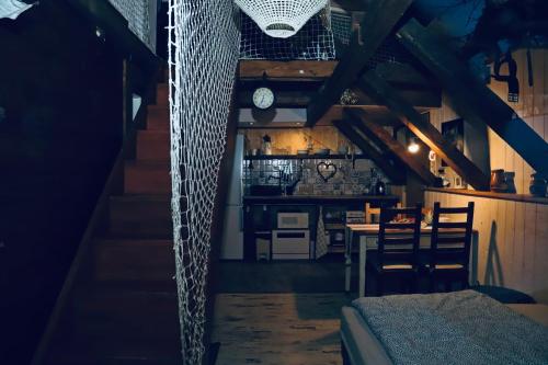 a room with a kitchen with a table and a clock at Chata u Kostela in Dolni Misecky