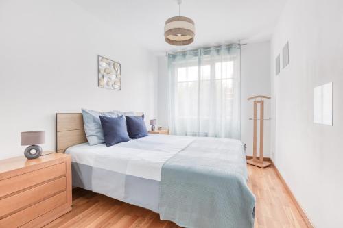 a white bedroom with a bed and a window at Cosy appartement Proche Disneyland Paris in Montévrain