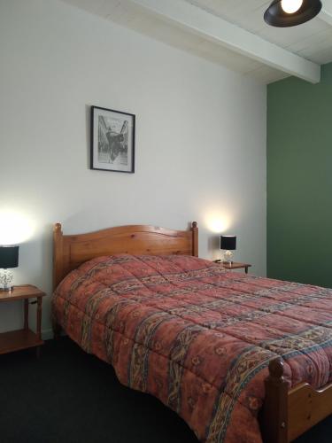 une chambre avec un grand lit avec une couverture rouge dans l'établissement Gite Jouvin, à Cerences
