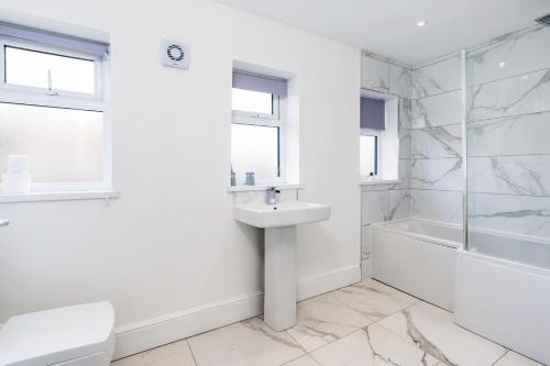 a white bathroom with a sink and a shower at Modern Contractor House & Free Parking & Garden in Hull