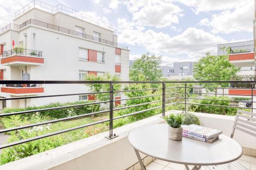 a balcony with a table and a building at Cosy appartement Proche Disneyland Paris in Montévrain