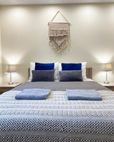 a bedroom with a large bed with blue pillows at MARCO Apartment 8 in Giżycko