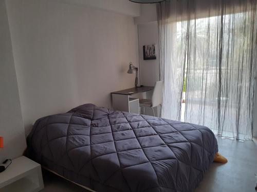 une chambre avec un lit et une grande fenêtre dans l'établissement F4 au cœur de Toulon 7 nuits minimum Wifi et parking commun gratuit, à Toulon