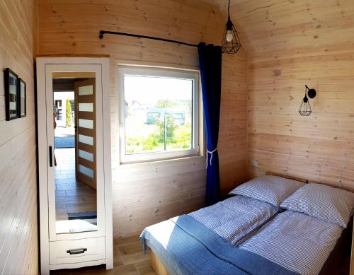 a bedroom with a bed in a wooden room at Domki Apartamentowe Rozgwiazdy 20 in Jarosławiec