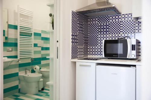 een badkamer met blauwe en witte tegels en een magnetron bij Little House - Massa Lubrense Sorrento in Massa Lubrense
