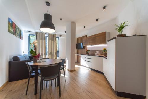 cocina y sala de estar con mesa y sillas en YUGOGO PELLICO 8 Trento Centro en Trento