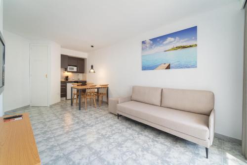 a living room with a couch and a kitchen at Apartamentos Ferrer Lime Playa de Alcudia in Port d'Alcudia