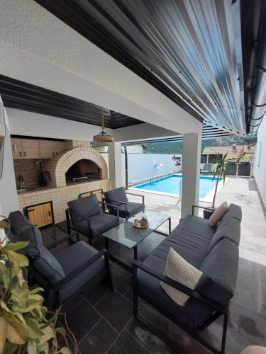 een woonkamer met een bank en stoelen en een zwembad bij Apartman Kiss in Jajce