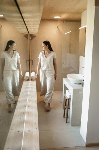 two women walking in a bathroom with a sink at Der Jägersberg in Fischen
