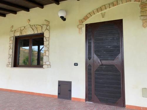 a house with a wooden door and a window at Monte Mosè in Agrigento