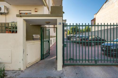 a gate to a building with a parking lot with cars at La Casa del Sole in Selargius