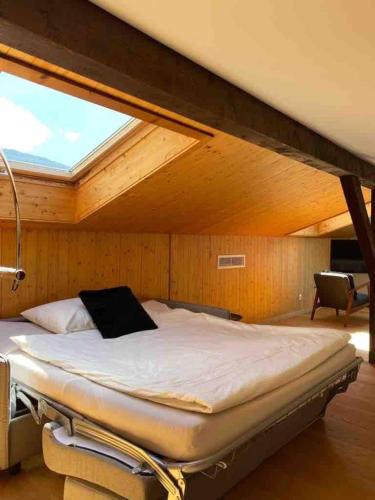 a large bed in a room with a window at Panorama Boutique Apartment with Air Condition, SPA entry in Solbadhotel in Sigriswil