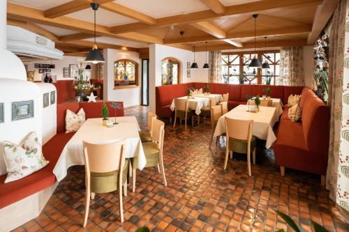 a restaurant with tables and chairs in a room at Familiengut Hotel Burgstaller in Döbriach