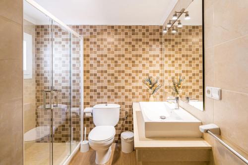 a bathroom with a toilet and a sink and a shower at Villa Sol y Sombra by Escape Home in Son Bou