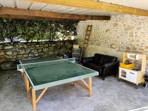- une table de ping-pong dans le salon avec canapé dans l'établissement Les Pieds dans l'eau, Gîte la Source, à Lachapelle-Auzac