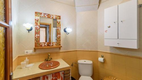 a bathroom with a toilet and a sink and a mirror at Villa Fuente Pintá Arenas by Ruralidays in Arenas
