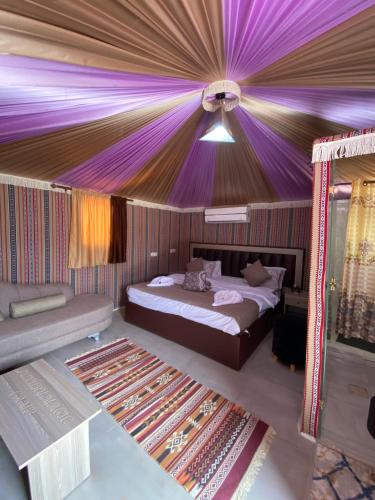 a bedroom with a bed and a purple ceiling at wadi rum land mars in Wadi Rum