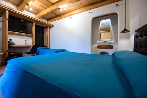 a bedroom with a blue bed in a room at Etna Quota Mille Boutique Hotel, Typical Sicilian Food & Wine in Randazzo