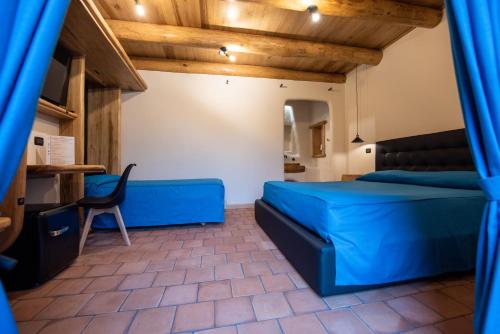 a bedroom with a bed and a chair in a room at Etna Quota Mille Boutique Hotel, Typical Sicilian Food & Wine in Randazzo