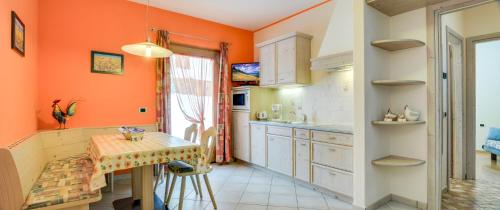 a kitchen with orange walls and a table in it at Aronne Bait Giobbe in Livigno