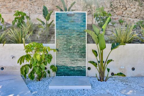 a mosaic shower in a garden with plants at Villa Mi Sueño - Pool⎜BBQgrill⎜Fast Internet⎜Workspace in Benissa