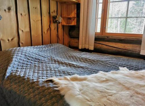 Un dormitorio con una cama con una manta. en Rukanhelmi jr. en Ruka