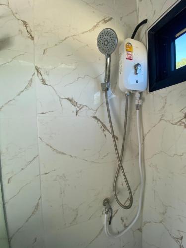um chuveiro com secador de cabelo na casa de banho em บ้านสไตล์คาเฟ่วังน้ำเขียว em Ban Kom