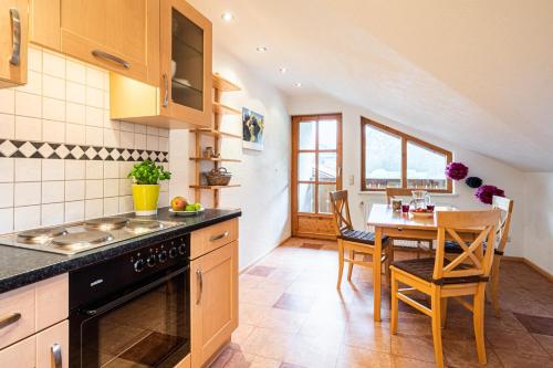 a kitchen with a table and a dining room at Ferienwohnung Brunnäcker in Bad Hindelang