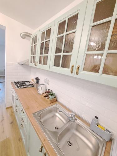 a kitchen with a sink and white cabinets at Apartman Karmen in Vodice