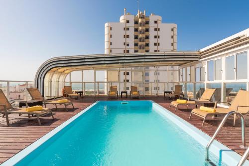 a swimming pool on the roof of a building at Hotel Baía De Monte Gordo in Monte Gordo