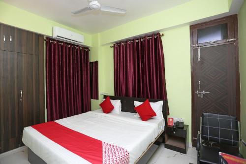 a bedroom with a bed with red pillows at Flagship Near Anisabad Golambar in Patna