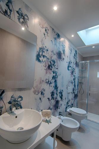 a bathroom with two sinks and a toilet and a shower at Villa Zavatta "B&B - Rooms & Apartments" in Bellaria-Igea Marina