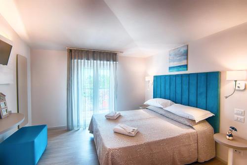a bedroom with a large bed with a blue headboard at Villa Zavatta "B&B - Rooms & Apartments" in Bellaria-Igea Marina