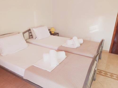a bedroom with two beds with white pillows at Frodo Studios in Kavos